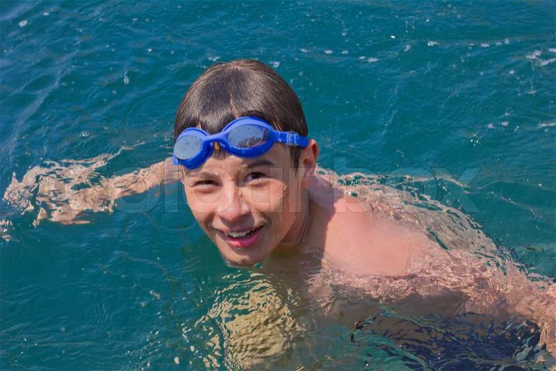 Junge im blauen Schwimmbrille schwimmen am Meer 