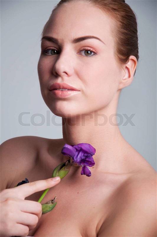 Hübsche junge Frau mit violetten Iris Blume, Stock-Foto